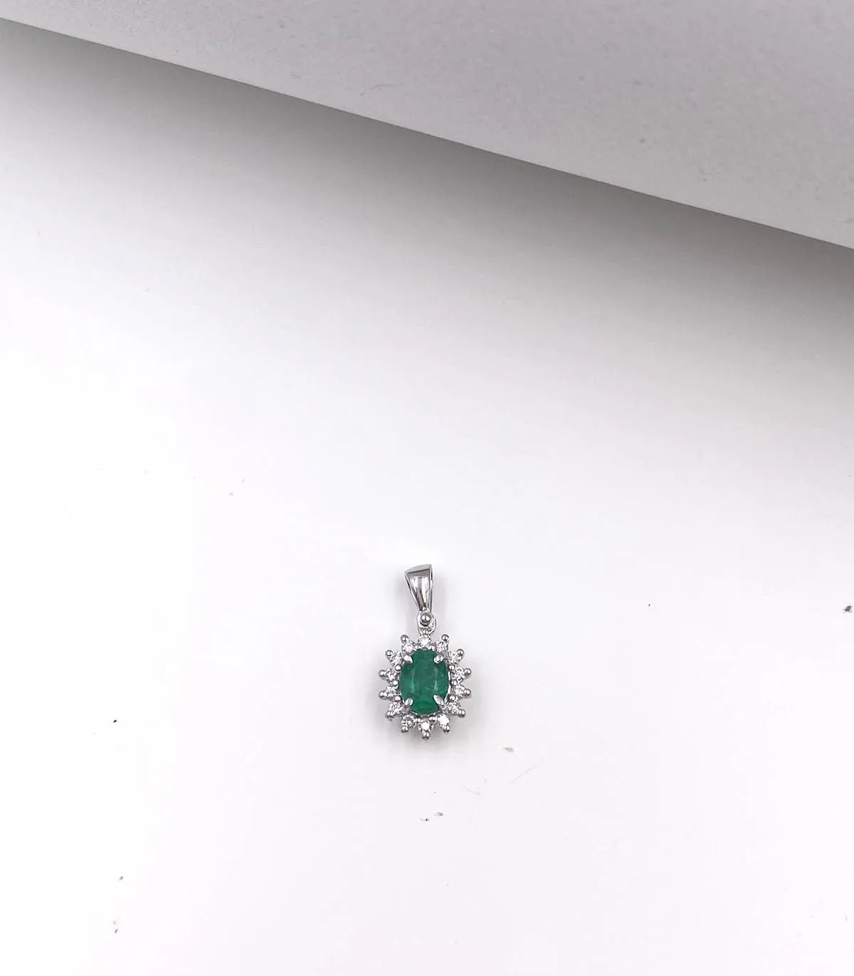 Ciondolo in oro bianco con smeraldo centrale da 0,30 carati e brillanti da 0,14 carati totali