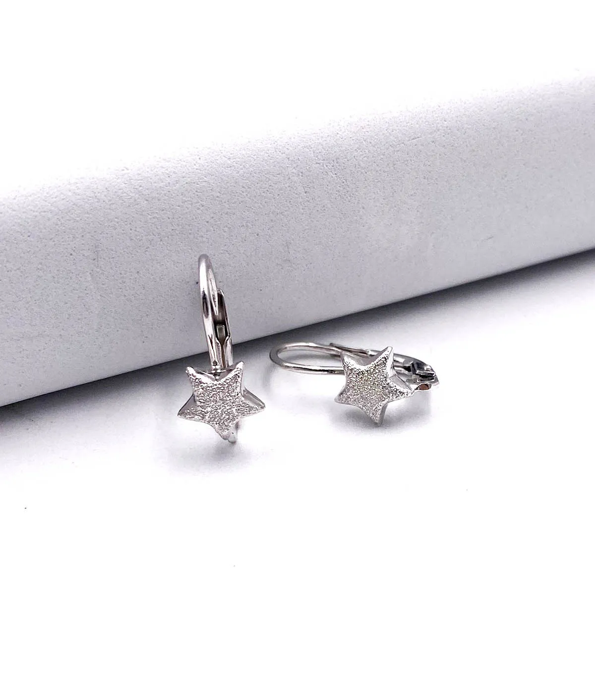 Orecchini in oro bianco a monachina con stella