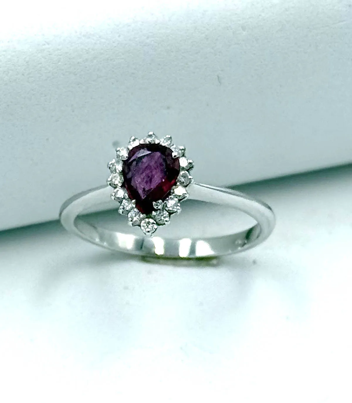 Anello in oro bianco con rubino a goccia da 0,60 carati e brillanti carati totali 0,32