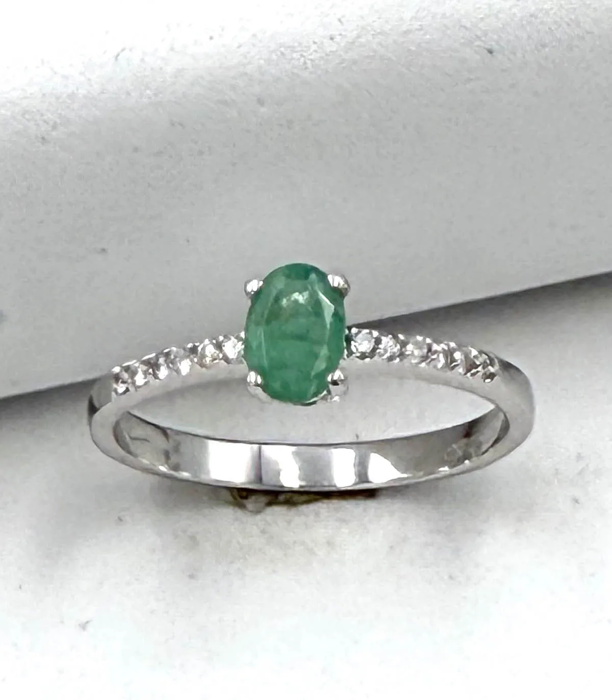 Anello in oro bianco con smeraldo centrale ovale da 0,40 carati e brillanti da 0,18 carati totali