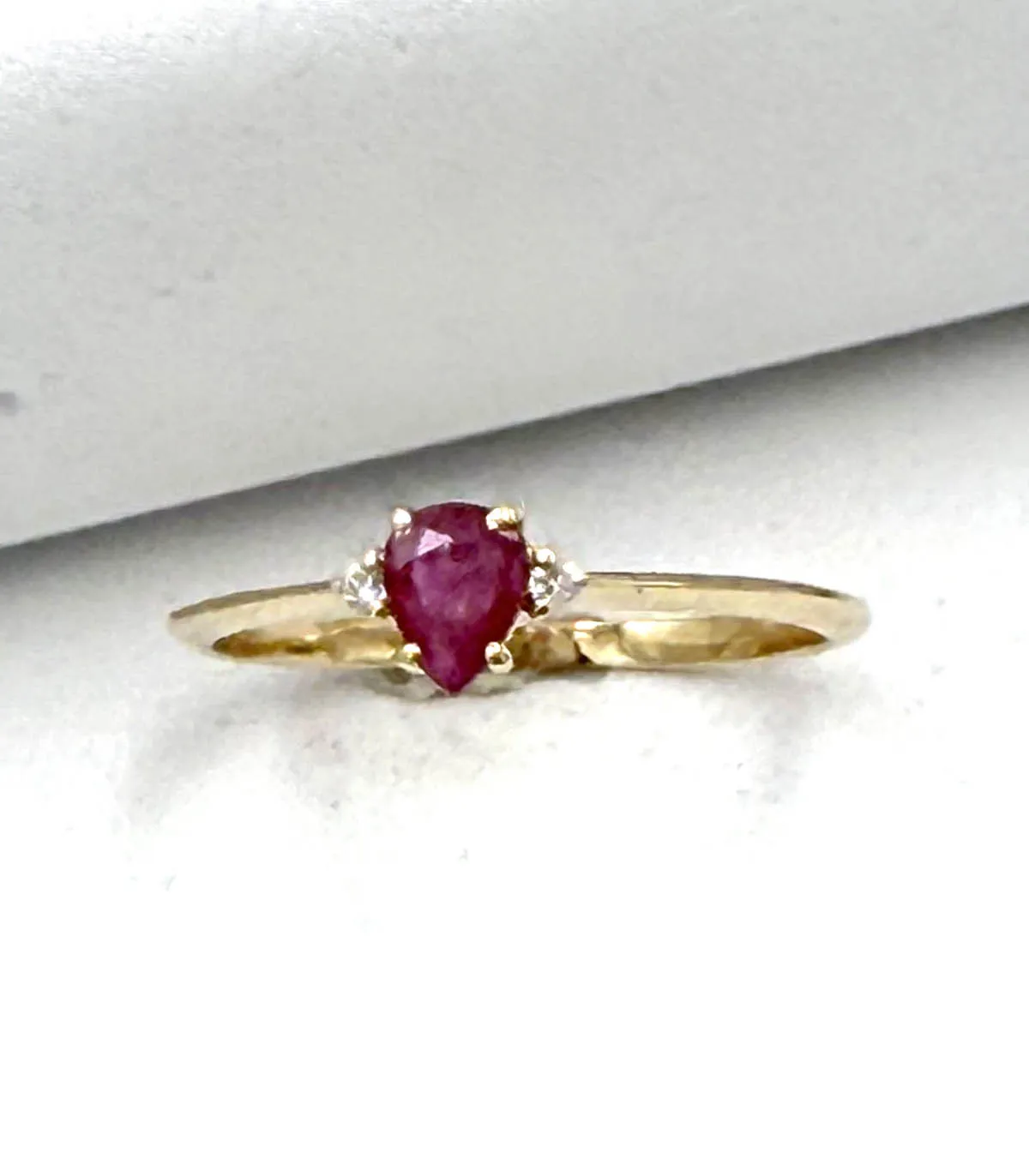 Anello in oro giallo con rubino centrale a goccia da 0,3 carati e brillanti carati totali 0,04