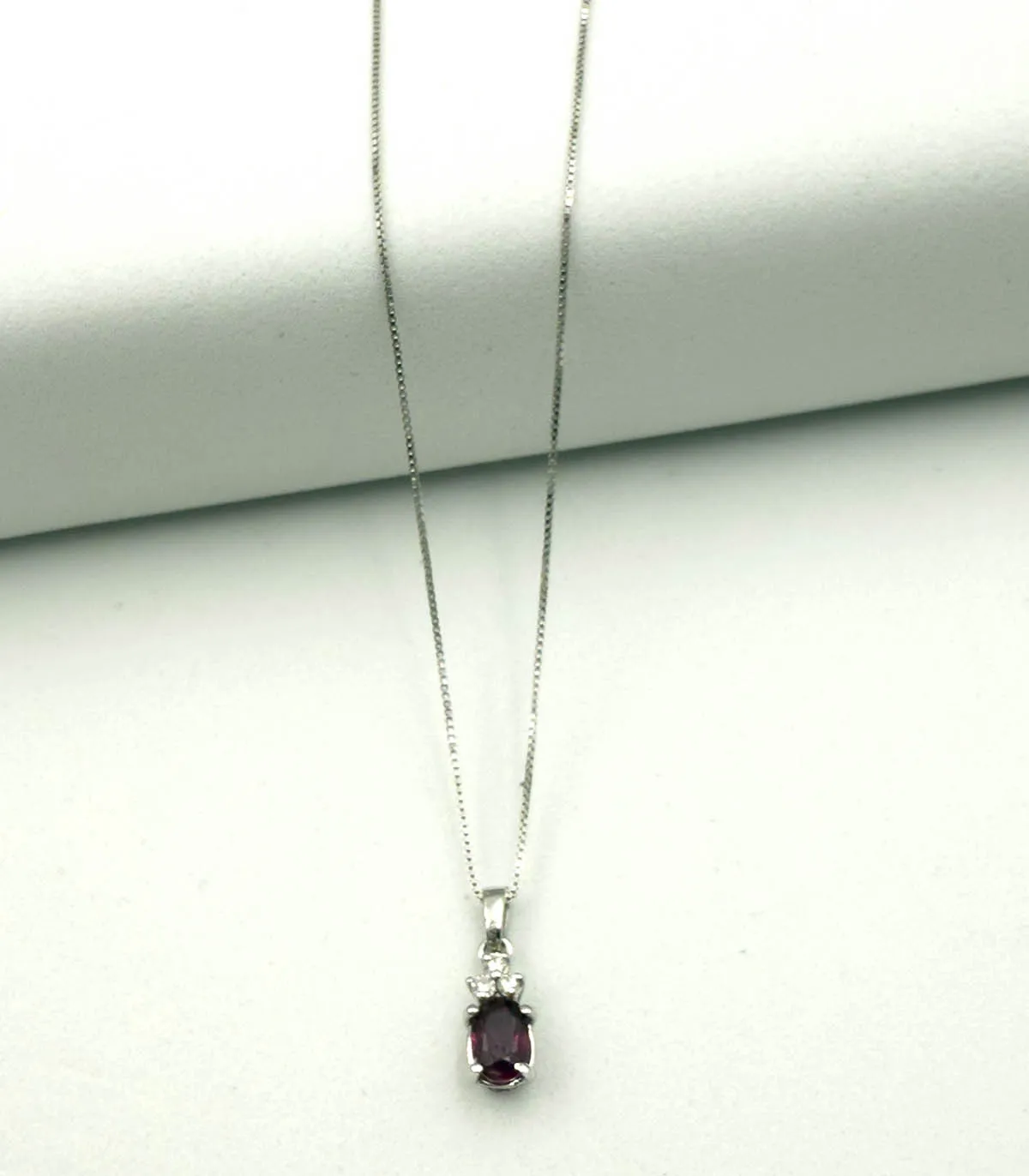 Collana in oro bianco con rubino ovale da 0,41 carati e brillanti carati totali 0,06