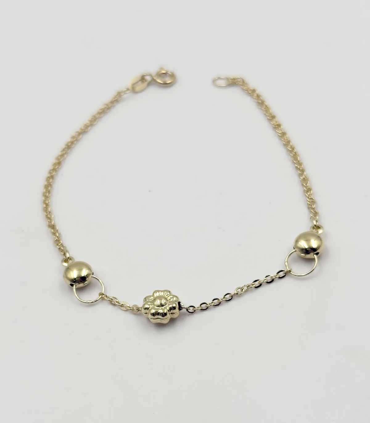 Bracciale in oro giallo con due sfere e fiore centrale