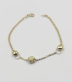 Bracciale in oro giallo con due sfere e fiore centrale